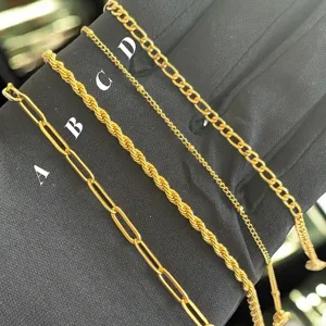Detailweergave van vier gouden rvs armbanden met paperclip- en getwiste kettingstijlen