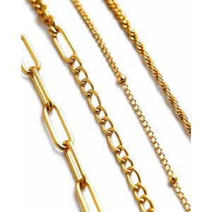 Detail van gouden roestvrijstalen armbandenset met paperclip- en cubaanse kettingen