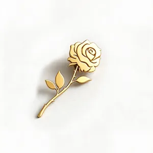 Detailed close-up view of a golden stainless steel rose brooch with stem and leaves