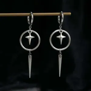 Detailopname van zilveren punk gothic oorbellen met geometrische kegel en ster