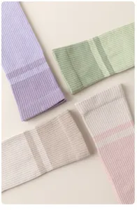 Gros plan détaillé des manchons de compression pour mollets en tricot côtelé rayé.