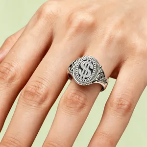 Close-up of a vintage hip-hop silver dollar sign ring with sparkling stones on hand