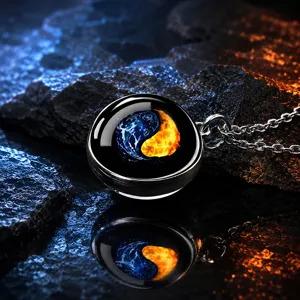 Κοντινό πλάνο μενταγιόν yin yang από γυαλί πάγου και φωτιάς σε ηφαιστειακό βράχο με αντανάκλαση.