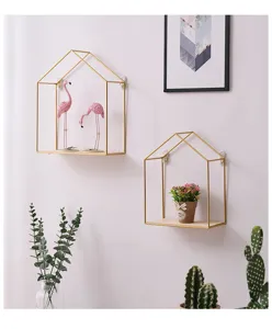 Detail view of house-shaped gold metal wall shelves with wood base in living room