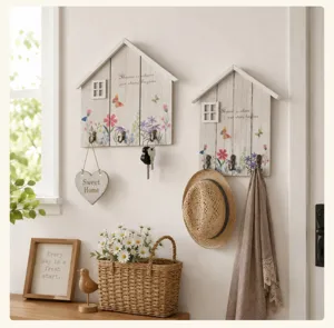 Rustic wooden house-shaped key holders mounted on a cozy and warm home entrance wall.