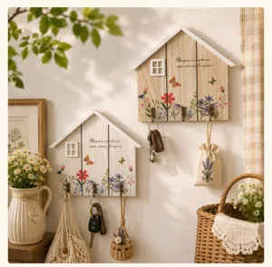 Rustic house-shaped wooden key holder with floral patterns and 'Home' quote on wall.