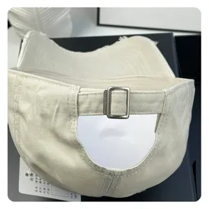 Beige cotton baseball cap with adjustable metal buckle, soft top and casual distressed style.