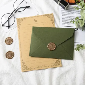 Vintage avocado green envelope and kraft paper stationery set with wax seal stamp detail.