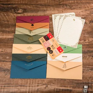 Ensemble de papeterie vintage avec enveloppes colorées, papier à lettres et autocollants de scellement.