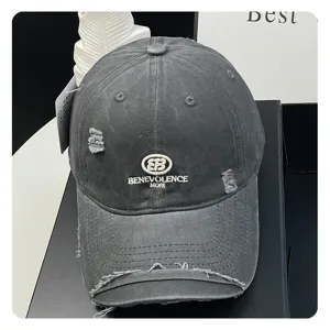 Distressed washed black baseball cap with embroidered letters and stylish oval logo for women.