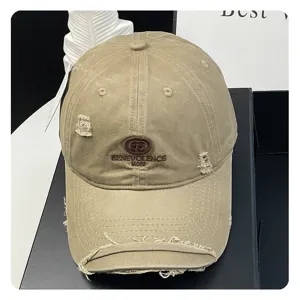 Distressed baseball cap closeup, vintage washed cotton fabric with detailed embroidery text.