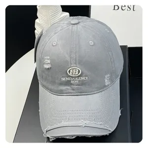 Grey distressed baseball cap detail featuring embroidered letters and vintage washed fabric.