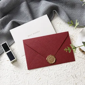 Elegante set di biglietti d'auguri con busta rossa strutturata e sigillo di cera per feste speciali.