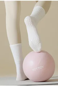 Vista detallada de calcetines de yoga blancos acanalados con puntos de silicona antideslizantes.
