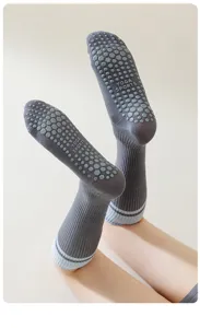 Vue détaillée de chaussettes de yoga grises avec des points en silicone hexagonaux antidérapants.