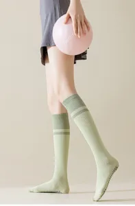 Gros plan de chaussettes de yoga de compression rayées respirantes avec picots antidérapants.