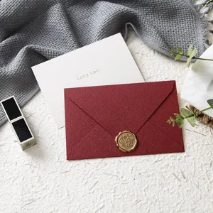 Elegante set di biglietti d'auguri con busta rossa strutturata e sigillo di cera per feste.