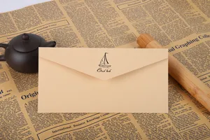 Gros plan d'une enveloppe rétro en papier kraft avec un voilier imprimé et texte de voeux.