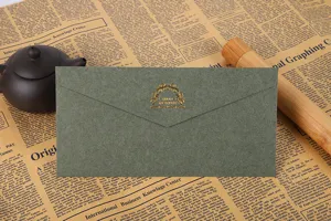 Enveloppe classique en papier spécial vert foncé avec marquage à chaud doré, vue de détail élégante.