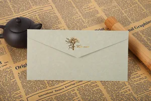 Vue détaillée de l'élégante enveloppe en papier spécial gris-vert avec arbre doré.