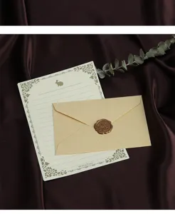 Vintage stationery set met briefomslag in linnenstructuur, briefpapier en waszegel.