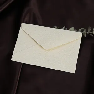 Gedetailleerde close-up van gestructureerde beige envelop, elegante briefpapier op zijde.