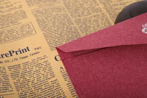 Détail d'enveloppe rouge texturée, papier spécial de qualité supérieure, art floral élégant.