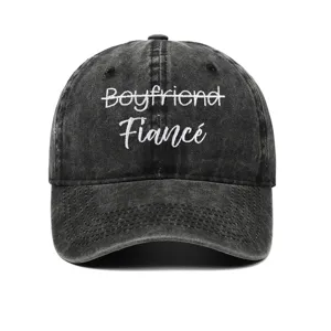 Close-up detail of 'Fiancé' white embroidery on washed black vintage baseball cap