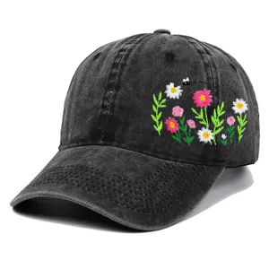 Detail der bunten Blumen- und Bienenstickerei auf gewaschener schwarzer Baumwollkappe