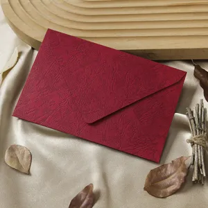 Retro red textured paper envelope detail view, vintage stationery prop for special letters.