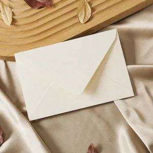 Detailed view of vintage textured paper envelope on silk background with wooden decor prop.