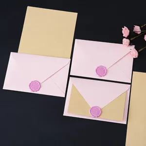 Detail view of pink envelopes and kraft letter paper set with elegant wax seal stamp for romantic letters.