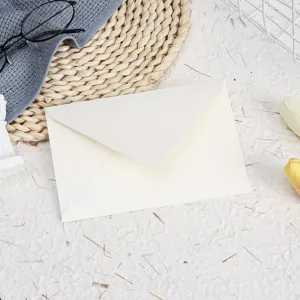 Cream paper envelope detail close-up, simple minimalist stationery flat lay design.