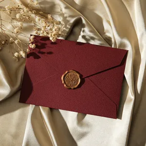 Enveloppe texture lin vintage avec sceau de cire et détail de fleurs séchées pour lettres.
