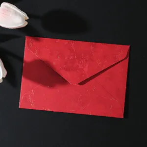 Vista dettagliata della busta retro rossa dorata, carta elegante per lettere d'invito.
