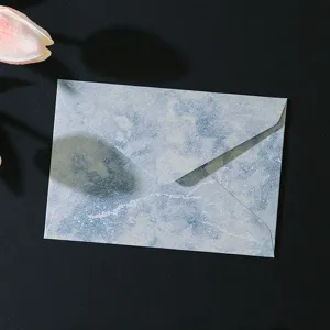 Primo piano dettagliato della busta retrò blu marmorizzata con delicata finitura dorata.