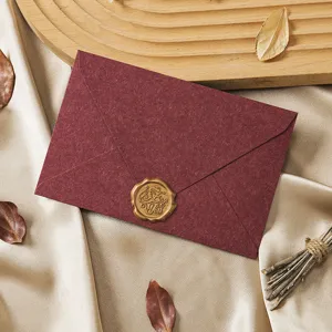 Close-up detail of vintage dark red envelope with golden wax seal for romantic letters.