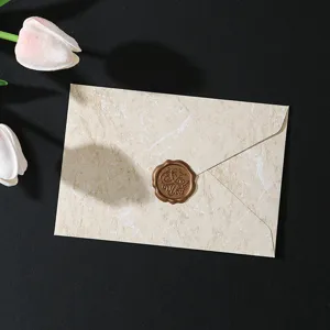Busta per lettere con texture marmo retro e sigillo in cera per invito romantico.