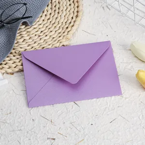 Purple pearlescent envelope detail shot with textured paper background and delicate aesthetic props.