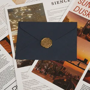 Gros plan détaillé de l'enveloppe bleu foncé texturée avec sceau de cire dorée pour lettres.