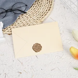 Detail view of a classic beige envelope with vintage wax seal stamp, elegant stationery prop.