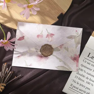 Detailed view of vintage floral embossed envelope with wax seal, elegant stationery item.