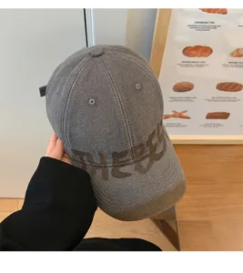 Primo piano dettagliato del berretto da baseball grigio con stampa retrò e visiera.