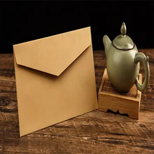 Gros plan détail d'une enveloppe en papier kraft marron vintage sur table en bois.