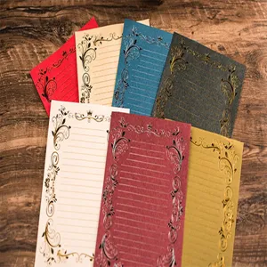 Close-up detail of vintage gilded stationery letter paper featuring elegant floral border patterns.