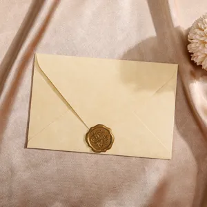Retro vintage style parchment envelope detail with golden wax seal on silky champagne fabric design.