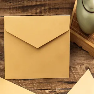 Vue de détail d'une enveloppe en papier kraft rétro épaisse sur fond en bois, épurée.