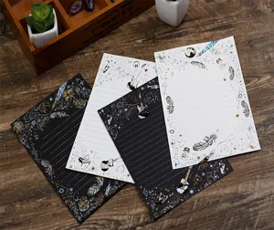 Elegantes Briefpapier Set mit edler Goldprägung, Sternen und Federn für kreative Briefe.