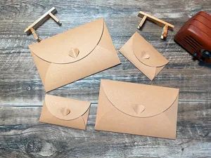 Detail shot of vintage kraft paper envelopes with cute heart clasps in various sizes.