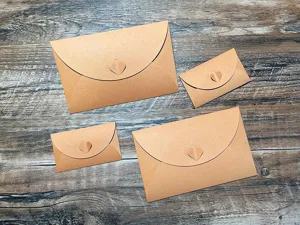 Close-up detail of brown kraft paper envelopes featuring an elegant heart clasp design.